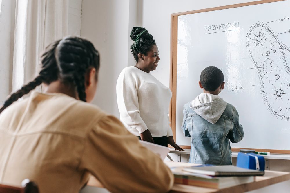 Black teacher exploring a classroom lesson with a diverse group of students
