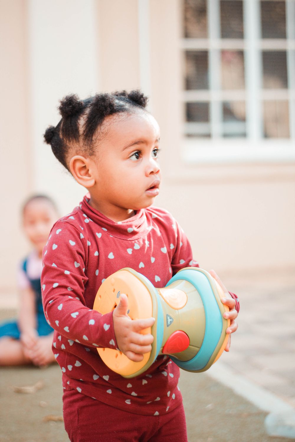 Young child exploring a colorful toy in a bright early learning room