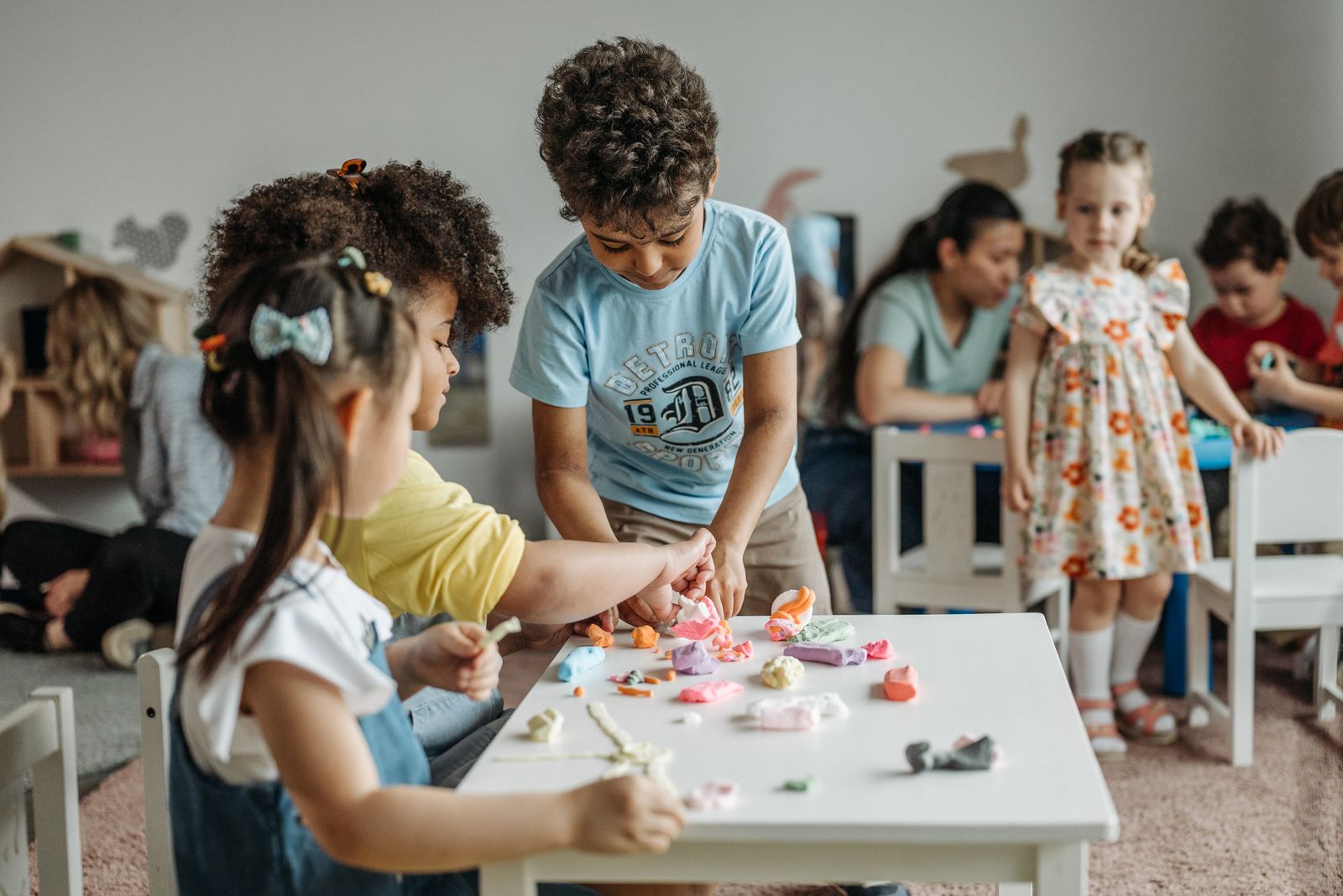 Diverse group of children shaping clay together during sensory play